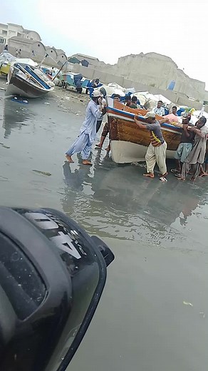 Loading and Unloading a Wooden Boat at Waterfront