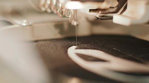 The automatic embroidery machine is working at high speed. Close-up