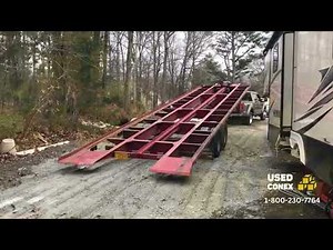 Shipping container delivery using a tilt-bed trailer.