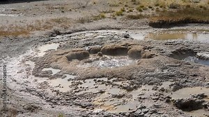 an active geyser spring with an intermittent discharge of water ejected turbulently and accompanied by steam