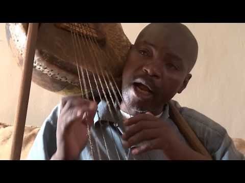 Shine Kibera - Playing Obokano 8 stringed Instrument