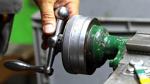 Close Up of Hand Operating Metal Lathe with Dial Indicator