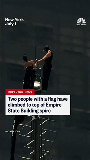 Two people climb the Empire State Building spire