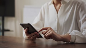 Download Woman using Smartphone on the Table for free