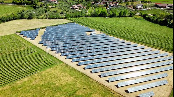 Solar panels in grape rows in Italian farmland, drone footage. Renewable energy deployment and modernization of rural power mix