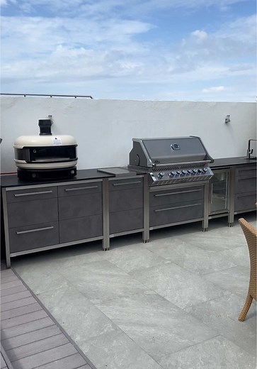 An outdoor kitchen made for the view.🤩 This outdoor kitchen is made for cooking with a view. Set in a garden overlooking the harbour, it completes the space with everything you need for outdoor living. 🌿There’s a Gozney Dome for wood-fired pizza nights, a Napoleon Prestige Pro for BBQs, a sink and tap for easy clean-up, and a Burnout fridge to keep drinks cold. Granite worktops offer loads of prep space, with plenty of built-in storage throughout. A seating area sits just next to the kitchen —