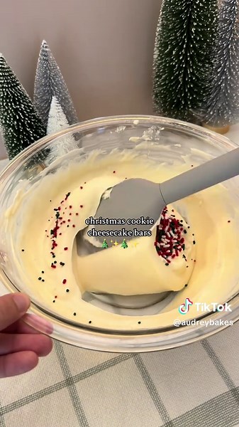 Christmas Cookie Cheesecake Bars ✨🎄 A cute and easy recipe, perfect for christmas! (recipe makes an 8x8 pan) Ingredients: ~2 packs of pillsbury christmas sugar cookies (I used 25 for the bottom of the pan and 9 for the top, and had some leftovers) 16 oz (454g) cream cheese, softened (block style, not spreadable) ½ cup (100g) granulated sugar 2 Tbsp (30g) sour cream 1 tsp vanilla extract 1 tbsp all-purpose flour Pinch of salt (optional) 1 large egg, room temp 2 tbsp christmas sprinkles (jimmies)