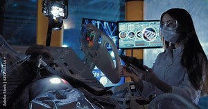 Beautiful female scientist fixes surveillance devices on an alien. Space alien lying on the operating table in the laboratory.