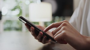 Download Woman using a Smartphone on the Table for free