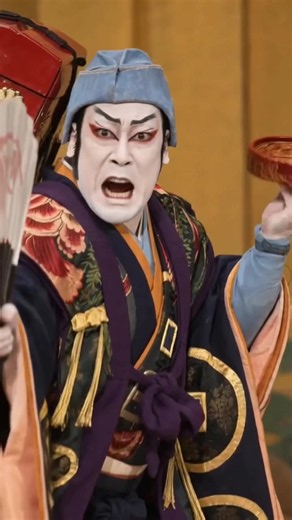The Medicine Peddler (Uirō) is a 1931 woodblock print by the Japanese artist Ōta Masamitsu, depicting a dramatic scene from the famous Kabuki Juhachiban (Eighteen Great Kabuki Plays). The artwork captures a Kabuki actor in the role of Soga Gorō, who has disguised himself as the Odawara medicine vendor Toraya Tōkichi to seek revenge for his father’s murder. Dressed in striking, ornate theatrical robes adorned with giant coin motifs and carrying a traditional medicine box on his back, the figure h