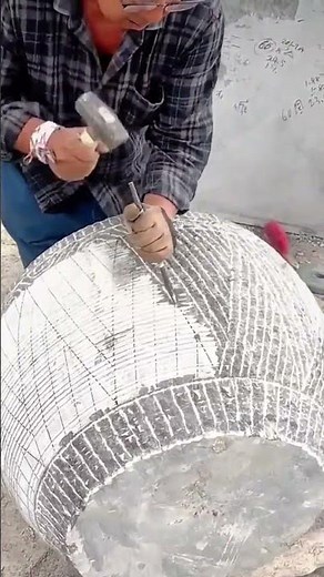 Carving detailed patterns on stone sphere with chisel