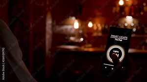 Smart light app on the smartphone getting used to turn on the lights in a restaurant