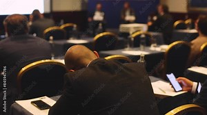 Audience at the modern conference hall listens to panel discussion, people on a congress together listen to speaker on stage at convention, business seminar, amphitheater venue for presentation