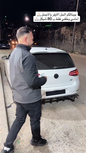 Removing License Plate from Parked Volkswagen at Night