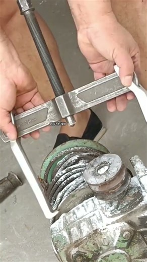 two-jaw bearing or gear puller being used to remove a component from a shaft