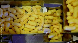 Sweet healthy puffcorn sticks making. Factory producing crispy corn sticks.